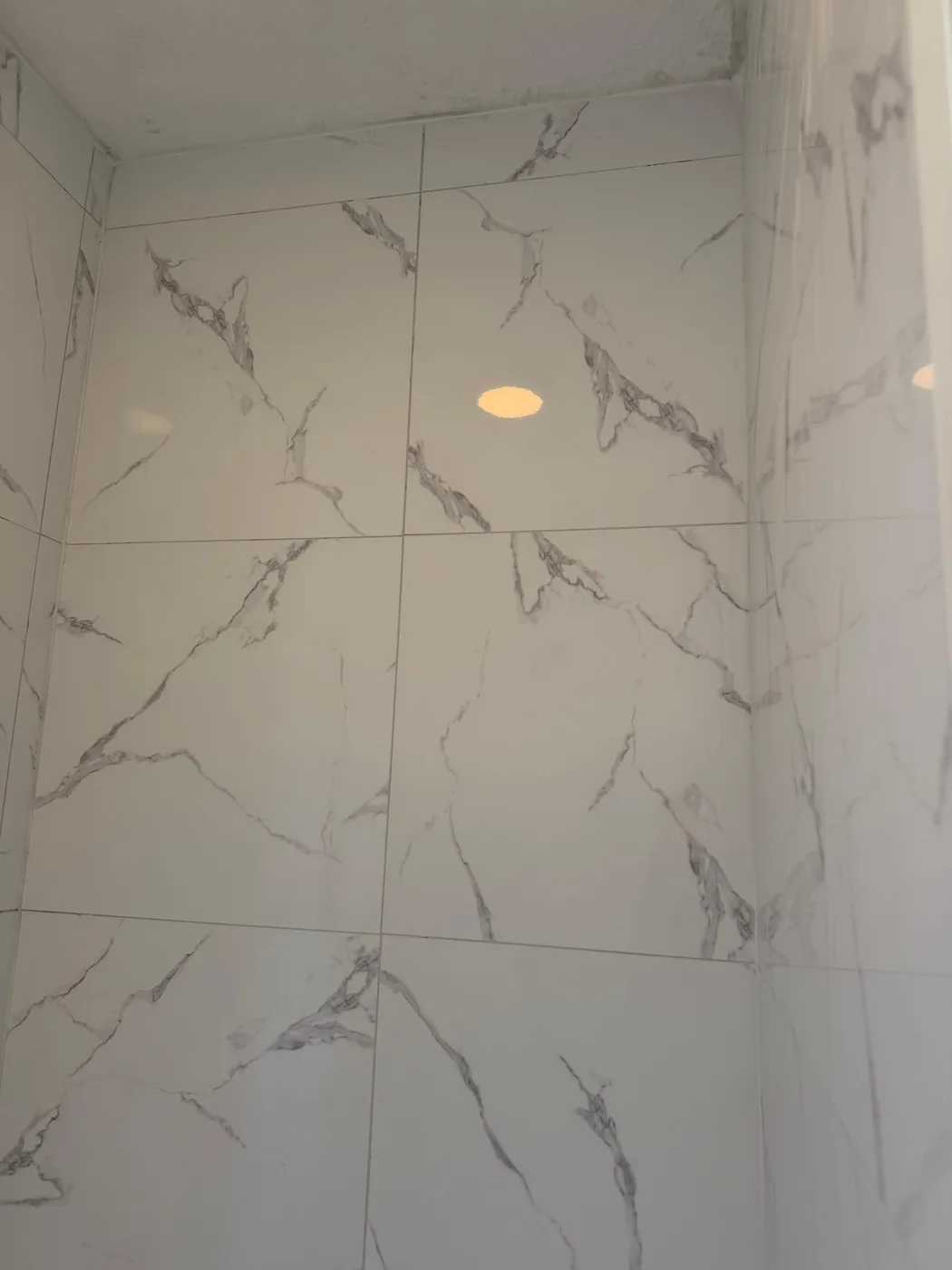 Walk-in shower in large-format marble-look tile